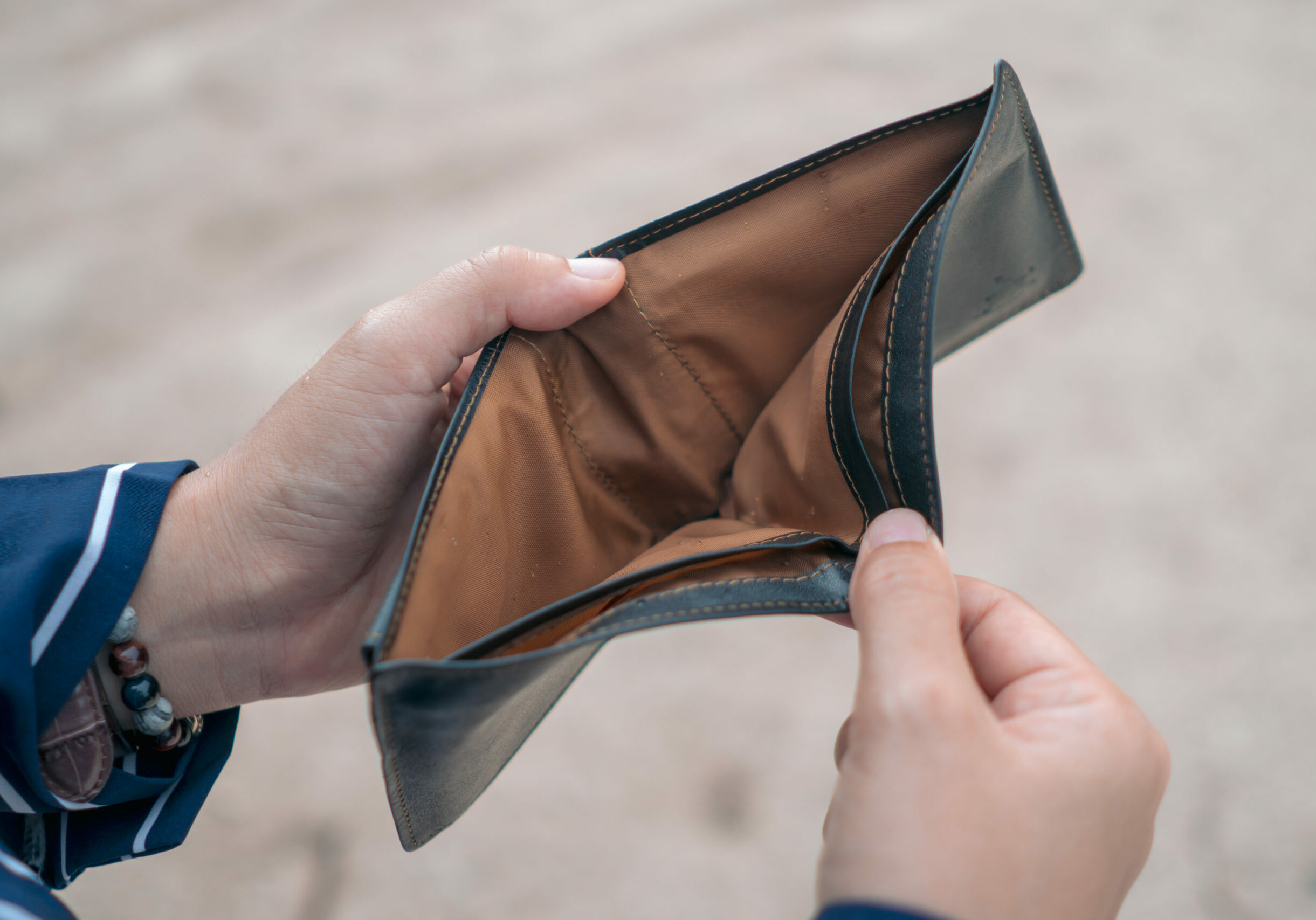 Woman holds an empty purse and coins in hand meaning money financial problem or bankrupt jobless, broke after credit card payday jobless, debt concept.