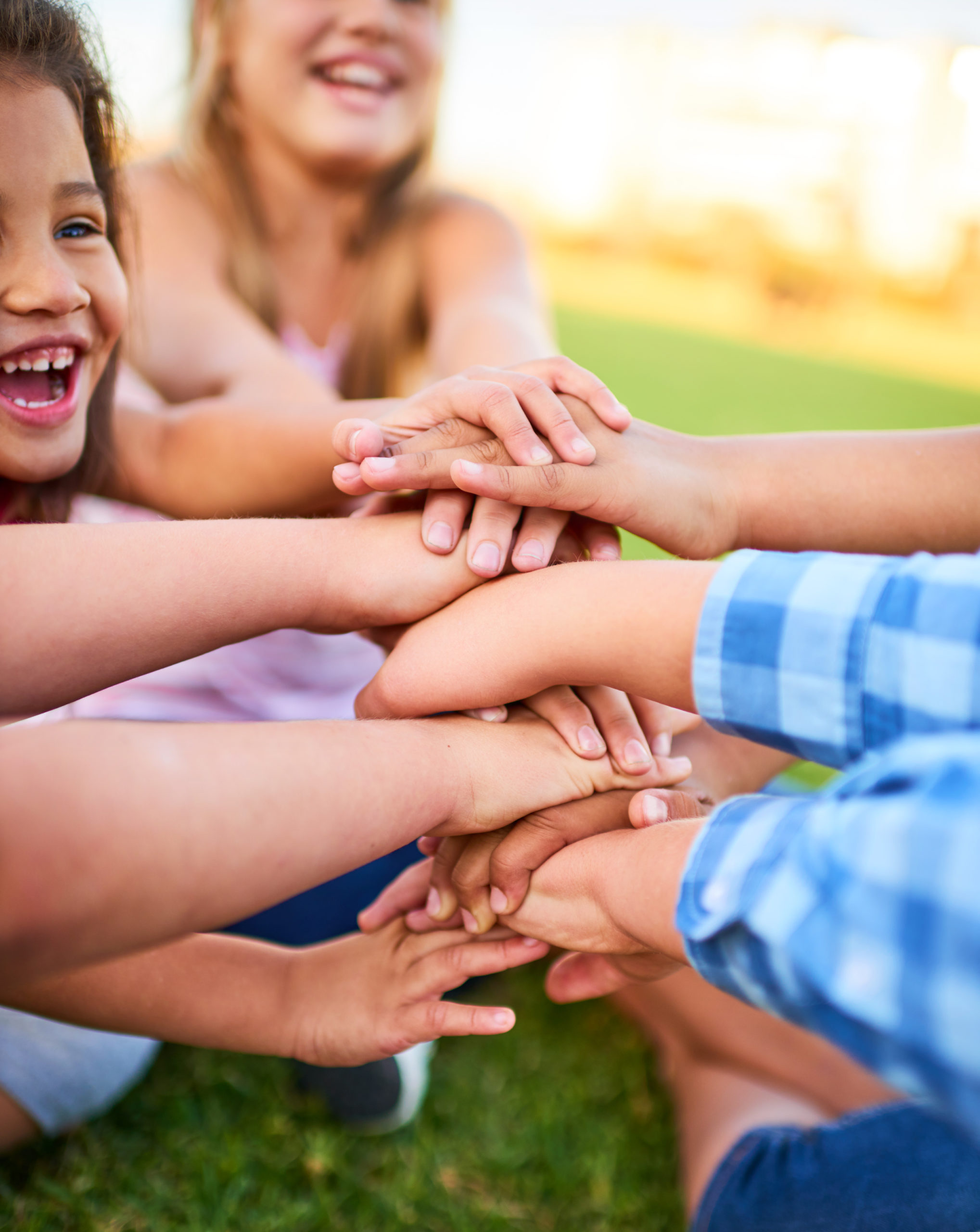 Cropped shot of a group of kids stacking their hands on top of each other.